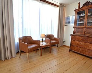 Stylish sitting area in Orchismient 35 vacation home, De Koog Texel, with antique cabinet.