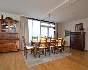 Large dining table in Orchismient 35 vacation home, De Koog Texel, with wooden chairs.