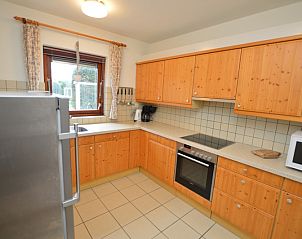 Fully equipped kitchen in Orchismient 35 vacation home, De Koog Texel, with wooden cabinets.