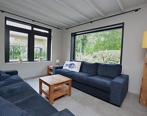 Gemtliches Wohnzimmer in der Ruijslaan 73, De Koog, Texel, mit bequemen Sofas und groen Fenstern.