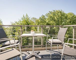 View from the terrace of Type 3B vacation home in De Koog, Texel, with comfortable seating and green surroundings.
