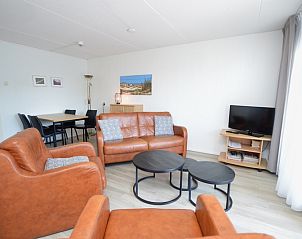 Attraktiv eingerichtetes Wohnzimmer im Motel Texel - Apartment 208/1L, De Koog, Texel, mit Ledersitz und Essecke.