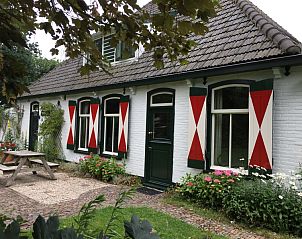 Cozy terrace at Voorhuis vacation home in De Koog Texel surrounded by greenery.