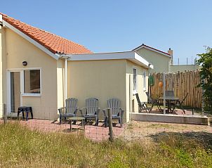 Spacious terrace at De Duinpan - Duinhuisje Texel, De Koog, with comfortable chairs and surrounded by nature.