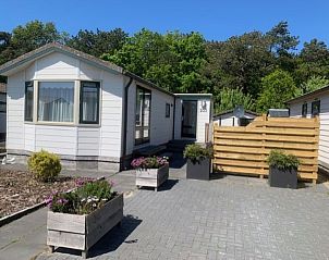 Vacation home Chalet Bregkoog 203, located in De Koog, Texel, with spacious driveway and green surroundings.