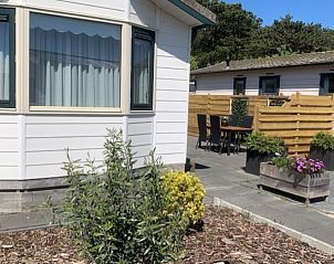 Terrace Chalet Bregkoog 203 on Texel, De Koog with cozy seating area and green plants.