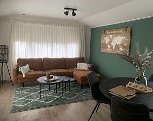 Stylish living room Chalet Bregkoog 203 in De Koog, Texel with comfortable sofa and world map decoration.