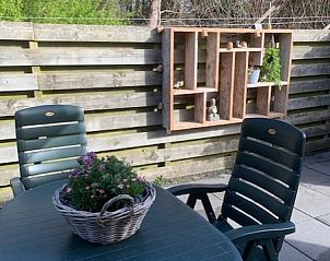 Outdoor area Chalet Bregkoog 203 in De Koog, Texel with garden furniture and wooden fence.