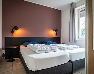 Attraktives Schlafzimmer im Bungalow 31, De Koog, Texel mit bequemen Betten und warmer Beleuchtung fr eine erholsame Nachtruhe.