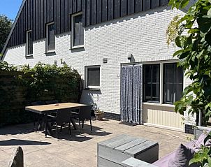 Enjoy the sunny patio at Cottage in De Koog, Texel, with comfortable outdoor furniture and green surroundings.
