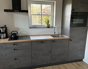 Dining room of Cottage in De Koog on Texel, featuring a rustic wooden table and art on the wall.
