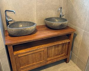 Stylish bathroom with double sink in cottage in De Koog, Texel, fitted with natural stone washbasins.