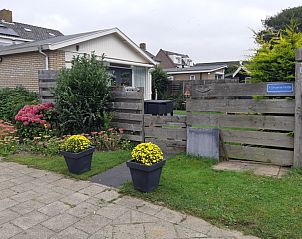 Exterior of vacation home De Anemoon in De Koog, Texel, surrounded by colorful flowers.