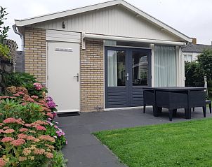 Terrace of vacation home De Anemoon in De Koog, Texel, with modern garden furniture and green surroundings.
