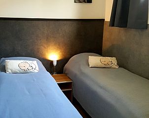 Second bedroom of De Anemoon in De Koog, Texel, with two single beds and night lights.