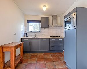 Moderne Kche von De Zonneweelde in De Koog, Texel, mit schlichten grauen Schrnken und Holzdetails.