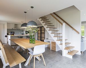 Modernes Esszimmer im Ferienhaus Buitenduin, De Koog, Texel mit Holztisch und Treppe.