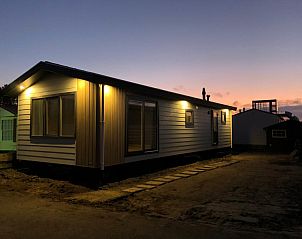 Chalet Bregkoog 262 in De Koog, Texel, illuminated at sunset, offers a serene atmosphere on the Wadden Islands.