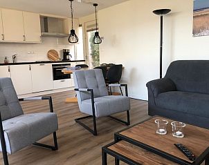 't Buitenhuisje in De Koog Texel, cozy living room of vacation home with modern furnishings and comfortable chairs.