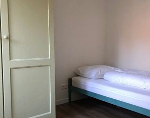 Simple single room in 't Buitenhuisje, vacation home De Koog Texel, with wooden floor and closet.