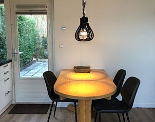 Cozy dining area in 't Buitenhuisje, vacation home De Koog Texel, with wooden table and atmospheric lighting.
