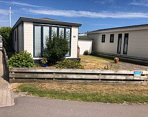 Chaletpark Bregkoog - Chalet Bregkoog 33, a charming vacation home in De Koog, Texel, with a cozy garden and wooden fence.