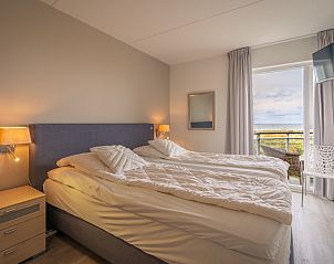Gerumiges Schlafzimmer im Appartement Juliana 116 Zeezicht, De Koog, Texel mit bequemem Bett und Balkon.