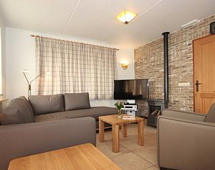 Gezellige woonkamer in 6 Persoons luxe villa met sauna, De Koog, Texel. Comfortabele zithoek met open haard en moderne voorzieningen.