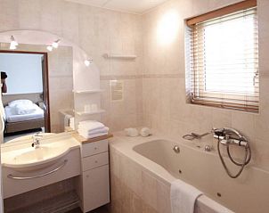 Luxe badkamer in 6 Persoons luxe villa met sauna, De Koog, Texel. Ontspannend ligbad en moderne faciliteiten voor ultiem comfort.