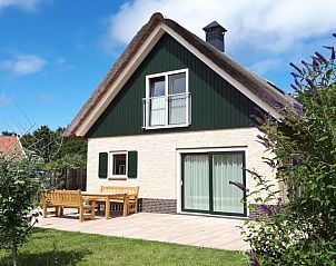 Zonnig terras bij Duinrand Vakantievilla's Type 2 in De Koog, Texel, perfect voor ontspannen buiten.