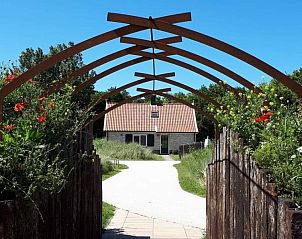 Bloemrijke ingang van Duinrand Vakantievilla's Type 2 in De Koog, Texel, met houten poort.