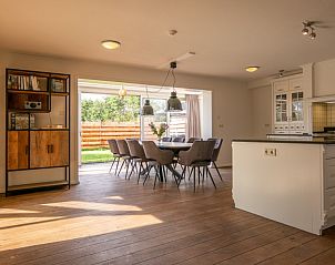 Eetruimte in vakantiehuis Kamerstraat 66, De Koog, Texel met uitzicht op de tuin.