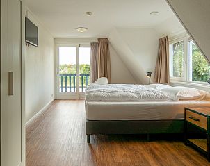 Slaapkamer met balkon in vakantiehuis Kamerstraat 66, De Koog, Texel voor frisse lucht.