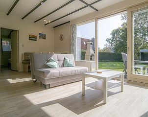 Lichte woonkamer van vakantiehuis Californiweg 142 met uitzicht op de tuin in De Koog, Texel.