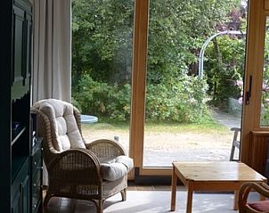 Comfortabele leeshoek in Vredelust 283 bungalow, De Koog, Texel, met tuinzicht.