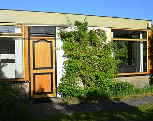 Vooraanzicht van Vredelust 283 bungalow in De Koog, Texel, omgeven door groen.