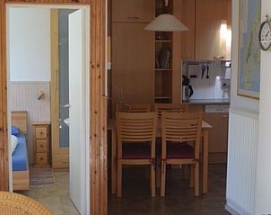 Eetkamer en keuken in Vredelust 283 vakantiehuis, De Koog, Texel, met houten interieur.