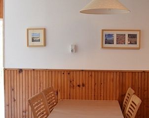 Eethoek in Vredelust 283 vakantiehuis, De Koog, Texel, met houten tafel en stoelen.