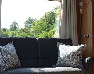 Comfortabele bank in Vredelust 283 bungalow, De Koog, Texel, met uitzicht op groene omgeving.