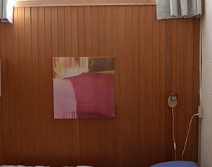 Eenpersoonskamer in Vredelust 283 bungalow, De Koog, Texel, met houten wand en kunst.