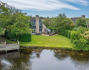Vacation home Honeysuckle 55 in De Koog Texel overlooking green garden and water feature.