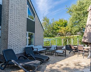 Sunny terrace at Holiday home Kamperfoelie 55 in De Koog Texel with comfortable deck chairs.