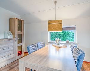 Dining room in Holiday home Honeysuckle 55 De Koog Texel with wooden table and modern lamp.