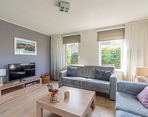 Modern sitting area in Holiday home Honeysuckle 63, De Koog, Texel with television and decoration.