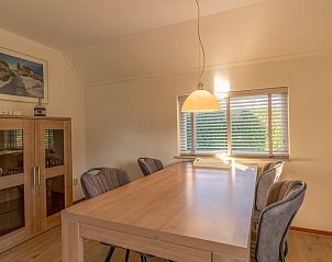 Dining room with wooden table in Holiday home Honeysuckle 63, De Koog, Texel.