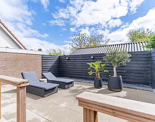 Gerumige Terrasse mit Liegesthlen im Appartement Zee van Tijd, De Koog, Texel. Perfekt zum Sonnenbaden und Entspannen.