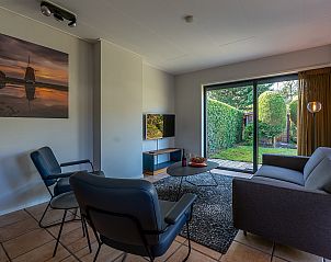 Bright living room of Zilte Bries vacation home in De Koog, Texel, overlooking garden.