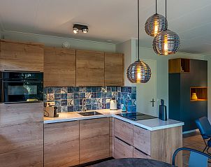 Modern kitchen in Zilte Bries vacation home, De Koog, Texel, with wooden cabinets and pendant lights.