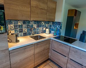 Detail of kitchen in Zilte Bries vacation home, De Koog, Texel, with tile wall and appliances.