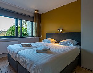 Comfortable bedroom in Zilte Bries vacation home, De Koog, Texel, with large window and double bed.